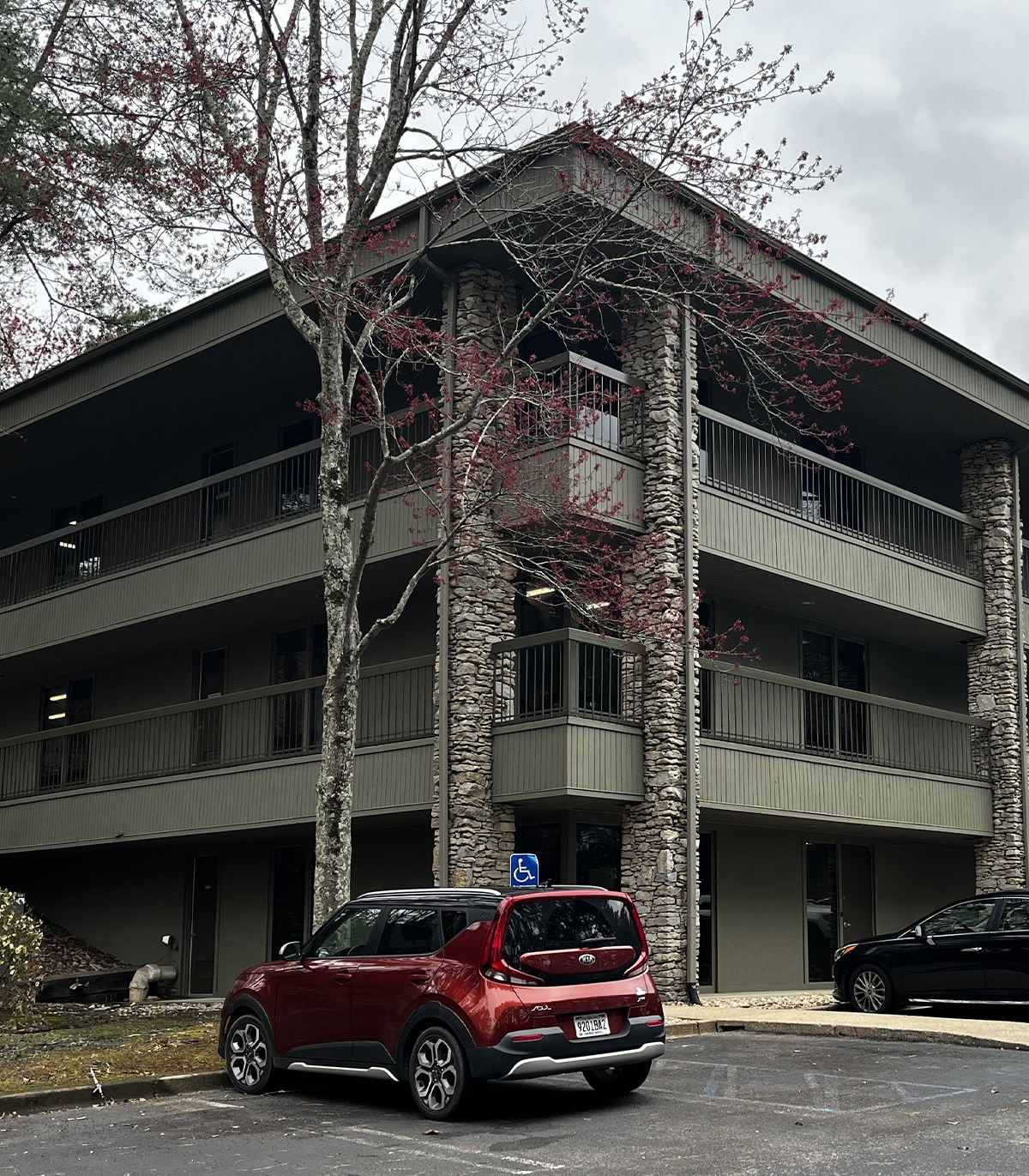 Exterior view of a multi-story building featuring stone accents, highlighting the services offered by Red Rock Realty Group's real estate professionals