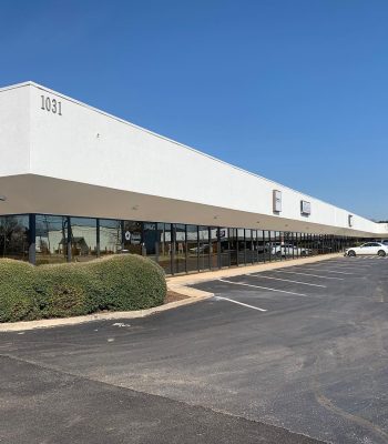 Exterior View Of A Commercial Building Featuring A Few Signage, Surrounded By Parked Vehicles, Representing Available Commercial Real Estate Opportunities