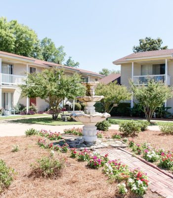 A House With Bushes In Front Of A Building